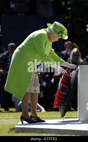 Königin Elisabeth II. Legt einen Kranz am Fuße des Opferkreuzes im Zentrum des Commonwealth war Graves Commission Cemetery, Bayeux, während eines Gedenkdienstes, Normandie, Frankreich. Stockfoto