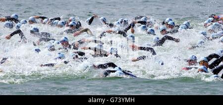 Teilnehmer der männlichen Sub 2 HR 30min Gruppe des Londoner Michelob Ultra Triathlon, die an der ersten Schwimmetappe teilnahm. Stockfoto