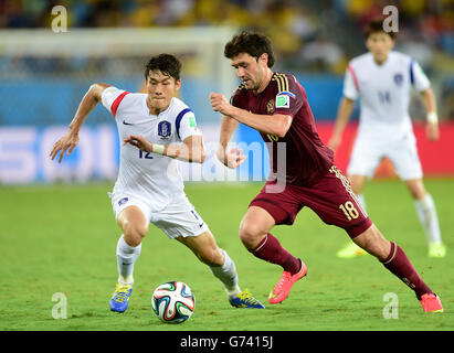 Fußball - FIFA Fußball-Weltmeisterschaft 2014 - Gruppe H - Russland gegen Südkorea - Arena Pantanal. Der russische Juri Lodygin (links) kämpft mit dem südkoreanischen Kim Shin-Wook um den Ball Stockfoto