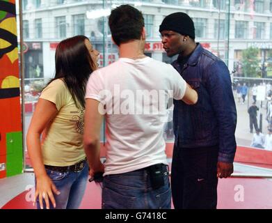 MTV-Moderator Dave Berry (Mitte) tritt während ihres Gastauftritts auf der TRL - Total Request Live - Show von MTV in ihren neuen Studios am Leicester Square im Zentrum von London zwischen den ehemaligen Big Brother-Mitbewohnern Emma und Victor auf. Stockfoto