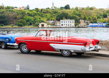 1950er Jahren amerikanische Lincoln Capri Cabrio Oldtimer in rot, geparkt vom Fahrer direkt am Meer in Havanna, Kuba Stockfoto