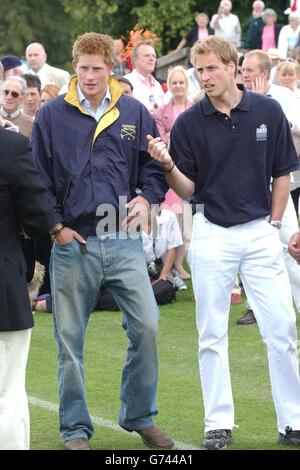 Prinz William (rechts) spricht mit seinem Bruder Prinz Harry, bevor William die Preise in der Queen Mother Trophy im Cirencester Park Polo Club überreichte. Stockfoto