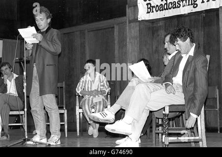 Der TV-Komiker Rik Mayall liest einen Auszug aus dem verbotenen Buch Spycatcher von Peter Wright bei einer Veranstaltung, die von der Campaign for Press and Broadcasting Freedom in der Conway Hall in London organisiert wird. Der ehemalige Monty Python-Mitglied Michael Palin sitzt auf der rechten Seite. Stockfoto