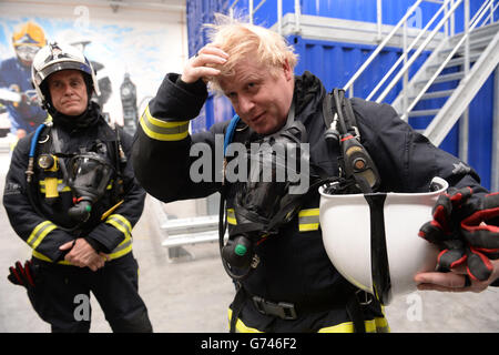 Der Bürgermeister von London Boris Johnson erlebt ein echtes "Feuerhaus" in der neuen Ausbildungsstätte der Londoner Feuerwehr in Beckton, Ost-London, und eröffnete offiziell das Millionen Pfund schwere Zentrum, das in der Lage ist, Feuerwehrmannschaften in einer Vielzahl von Brandbedingungen auszubilden. Stockfoto