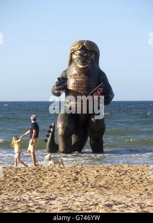 Eine 25 Meter hohe Seekreatur ähnlich Richard Branson taucht aus dem Meer auf Bournemouth Strand in Dorset mit einem TV, Laptop, Telefon und Handy, um die Einführung von Virgin Media Big Kahuna Quad-Play-Bundle zu feiern. Stockfoto