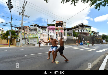 Brasilianische Jugendliche spielen barfuß auf den Straßen von Salvador Fußball In der Nähe der Arena Fonte Nova früh vor dem Start Stockfoto