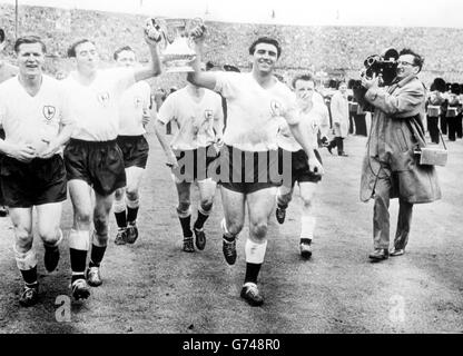 Tottenham Hotspors, Kapitän der rechten Hälfte, Danny Blanchflower (links) und Bobby Smith, der in der Mitte vorne ist, traben den FA Cup vor den 100,000 Zuschauern im Empire Stadium, Wembley nach dem Sieg von Spurs 2-0 über Leicester City im Cup-Finale Stockfoto