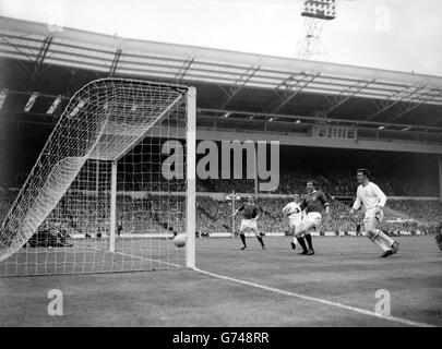 Manchester United Center-forward David Herd (dunkles Hemd zweite von rechts), der Torschütze, gibt einen Schrei des Triumphs, wie der Ball überquert die Leicester City goalline für United's zweites Tor im FA Cup Finale in Wembley. Manchester United gewann 3:1. Stockfoto