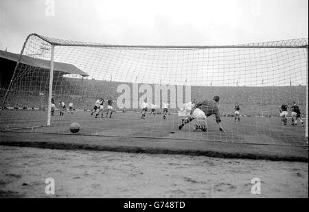 Der Ball hummt auf den Rücken des Burnley-Nettotorhüters Adam Blacklaw, der auf einem Knie von Tottenham Hotspur rechts in der Hälfte und Kapitän Danny blanchflower (links von Blacklaw) wegen des dritten Tores und einer zwei-Tore-Führung getroffen wurde. Im FA Cup Finale im Empire Stadium, Wembley. Das Spiel endete mit einem 3-1-Sieg für die Sporen, die den Pokal behalten. Stockfoto