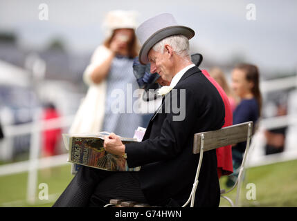 Ein Rennfahrer liest die Racing Post während des Investec Derby Day 2014 bei Epsom Downs Racecourse Stockfoto