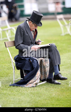 Ein Rennfahrer liest die Racing Post während des Investec Derby Day 2014 bei Epsom Downs Racecourse Stockfoto