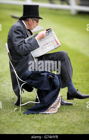 Ein Rennfahrer liest die Racing Post während des Investec Derby Day 2014 bei Epsom Downs Racecourse Stockfoto