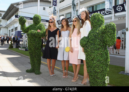 Rennfahrer stehen am Ladies Day auf der Rennbahn Epsom Downs am Eingang des Pavillons mit dem lebenden Topiary an Stockfoto