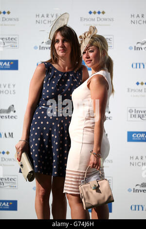 Pferderennen - Investec Ladies Day 2014 - Epsom Downs Racecourse. Rennfahrer stehen am Ladies Day auf der Rennbahn Epsom Downs an Stockfoto