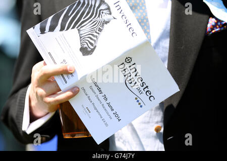 Pferderennen - Investec Derby Tag 2014 - Epsom Downs Racecourse. Rennfahrer lesen das offizielle Rennprogramm während des Investec Derby Day 2014 auf der Rennbahn Epsom Downs Stockfoto