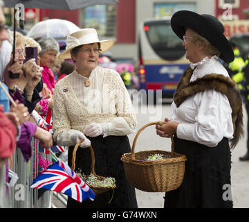 Zwei Damen, die zum Anlass des Ersten Weltkriegs in einem 1914-Jahre-Kostüm gekleidet waren, bevor Königin Elizabeth II. Und der Herzog von Edinburgh am dritten Tag des königlichen Besuchs in Nordirland das Rathaus von Coleraine erreichen. Stockfoto