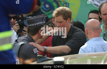 Prinz Harry umarmt einen Polizisten, als er das Open-Arms-Projekt besucht, das zur Reduzierung von Kriminalität und Drogenmissbrauch im Gebiet von Cracoladia außerhalb von Sao Paolo beiträgt, während er seine Reise durch Brasilien fortsetzt. Stockfoto