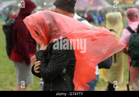 Festivalbesucher während eines Regenschauers auf dem Glastonbury Festival, würdig Farm in Somerset. Stockfoto