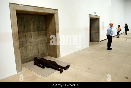 Besucher der neuen Ausstellung Human Factor: The Figure in Contemporary Sculpture der Hayward Gallery sehen sich ein Stück mit dem Titel Lying man von Paloma Varga Weisz an, das morgen für die Öffentlichkeit zugänglich ist. Stockfoto