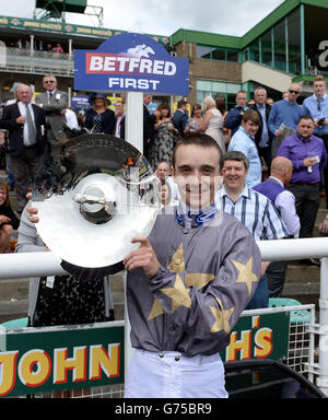 Der Jockey George Chaloner hält die Northumberland Plate Trophy, nachdem er während des John Smith's Northumberland Plate Day auf der Rennbahn in Newcastle auf Angel Gabrial in der John Smiths Northumberland Plate gewonnen hatte. Stockfoto