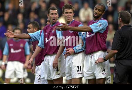 West Hams Don Hutchison (links), Michael Carrick (Mitte) und Frederic Kanoute klagen beim Schiedsrichter Graham Barber (rechts) während des FA Barclaycard Premiership Spiels zwischen West Ham United und Fulham im Upton Park, London. Stockfoto