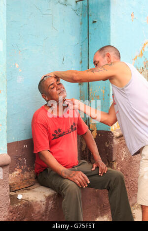 Outdoor-Barbier rasieren eine Mann auf der Straße in Trinidad, Kuba Stockfoto