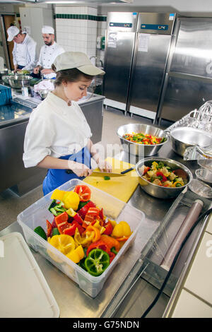 Kochlehrling schneiden Paprika für das Mittagessen. Stockfoto