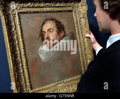 Ein Christie's Mitarbeiter schaut sich ein Portrait von Sir Anthony Van Dyck an, das im Rahmen des Old Master & British Paintings Sale bei Christie's in London versteigert wird. Stockfoto