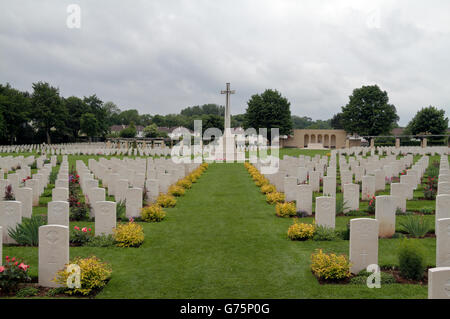 Kreuz des Opfers und Grabsteine in der CWGC Ranville War Cemetery, Ranville, Calvados, Frankreich. Stockfoto