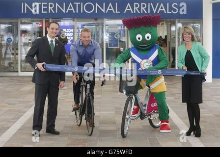 David Grevemberg (links) Chief Executive Glasgow 2014, Sir Chris Hoy (zweite links) und Amanda McMillan (rechts) Managing Director Glasgow Airport mit Maskottchen Clyde eröffnen den neuen internationalen Ankunftsbereich am Flughafen Glasgow vor den Commonwealth Games 2014 in Glasgow. Stockfoto