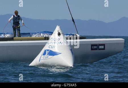 Bow man Matt Cornwell vom Team GBR sieht, wie seine Yacht Wight Lightning im Hauraki Golf vor Auckland, Neuseeland, über die Ziellinie hinkt. *...beim fünften Flug (Renntag) im ersten Round Robin des Louis Vuitton Cups siegen die Gegner von GBR Alinghi nach einem knappem Start bei außergewöhnlich leichten Bedingungen um vier Minuten 33 Sekunden. Segeln mit Achterschleifer Chris Main den Mast nach oben um die Lattens im Hauptsegel zu kicken, machte er einen Spalt einen Meter lang und zwang sie, sich auf dem letzten Unterwind-Bein zu entspannen. Stockfoto