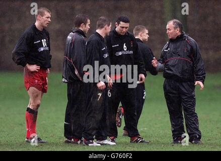 Wales-Cheftrainer Graham Henry unterhielt sich mit Stephen Jones (Nr. 6) und seinen Rückenkollegen während des Trainings in Sophia Gardens, Cardiff, vor dem Eröffnungsspiel von Wales in ihrem Lloyds TSB Six Nations-Spiel gegen Irland in Dublin. Stockfoto