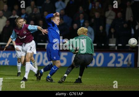 Chelsea's Mikael Forsesell (Mitte) schafft es, den Ball zwischen David James (rechts) und West Ham Verteidiger Tomas Repka zu quetschen, um den Ausgleich AXA FA Cup 4. Runde Wiederholung im Upton Park East London zu erzielen. Stockfoto