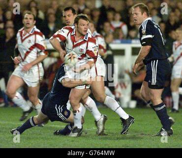 Die Saints' Keiron Cunningham (Mitte) sucht nach einem Teamkollegen, der bei ihrem Tetley's Bitter Super League-Spiel in der St Helen's Knowsley Road, Merseyside, gegen Wigan vorgeht. Stockfoto