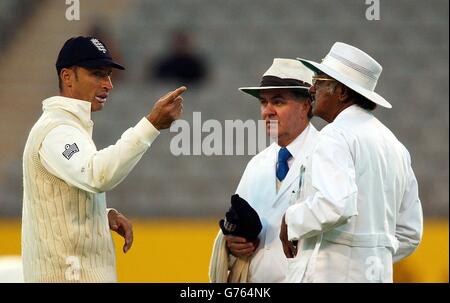 England-Skipper Nasser Hussain (links) spricht mit den Schiedsrichtern Doug Cowie (Mitte) und Srinath Venkataraghavan am vierten Tag des dritten und letzten Testspiel gegen Neuseeland im Eden Park, Auckland. *Hussain appellierte an die Bahnschiedsrichter, dass seine Feldspieler nach Sonnenuntergang keine rote Kugel vor dem Hintergrund eines schwarzen Himmels sehen konnten. Flutlichter wurden verwendet, um Zeitverluste durch Regen auszugleichen. Stockfoto