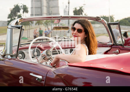 Eine Frau posiert in einem Oldtimer in Havanna, Kuba Stockfoto