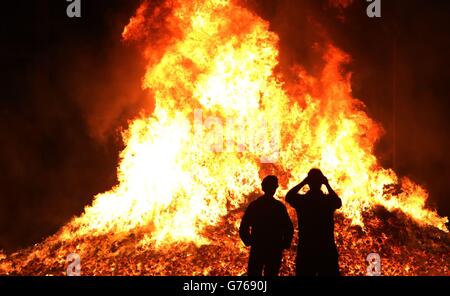 Am Vorabend der jährlichen Feierlichkeiten zum 12. Juli in Sandy Row, Belfast, fotografieren die Bürger bei einem Lagerfeuer, das den Sieg von König Wilhelm III. Über James II. Bei der Schlacht an den Boyne im Jahr 1690 markiert. Stockfoto