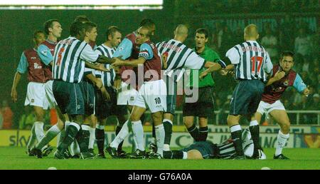 West Ham-Kapitän Paolo Di Canio versucht, Darren Moore (links Nr. 5) von West Brom zu beruhigen, als Joe Cole (ganz rechts) nach einer Kollision mit Sean Gregan (am Boden) während ihres Barclaycard Premiership-Spiels in Upton Park aufsteht. Stockfoto