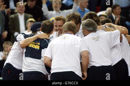 Der Schwede Thomas Johansson (gegenüberliegende Kamera) wird von seinem Team gratuliert, nachdem er den Briten Greg Rusedski beim Finale und entscheidenden Spiel im Davis Cup World Group Spiel in der National Indoor Arena, Birmingham, geschlagen hat. Stockfoto