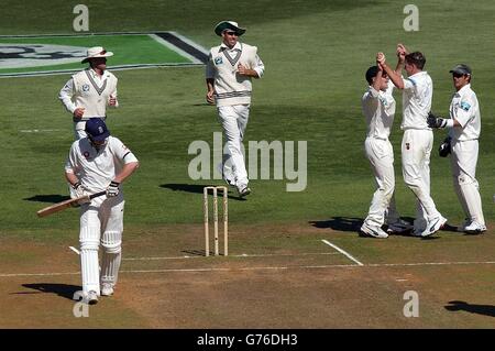 Der Engländer Andrew Flintoff (links) geht zurück zum Pavillon, nachdem er am dritten Tag des zweiten Testspieles im Basin Reserve, Wellington, von dem Neuseeländer Chris Drum beim Bowling von Ian Butler für 2 Läufe erwischt wurde. Am Ende des Spiels waren Neuseeland 70 - 1 als Antwort auf Englands 280 All-Out. Stockfoto