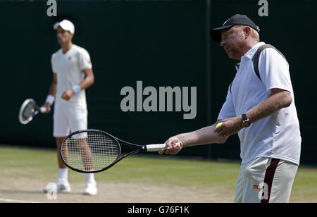 Tennis - Wimbledon Championships 2014 - Day Eleven - The All England Lawn Tennis and Croquet Club. Serbiens Novak Djokovic praktiziert, beobachtet von Trainer Boris Becker Stockfoto
