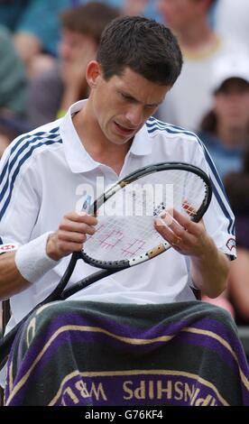 NUR FÜR REDAKTIONELLE ZWECKE, KEINE KOMMERZIELLE VERWENDUNG. Der britische Tennisstar Tim Henman für Männer wählt zwischen den Spielen gegen Wayne Ferreira aus Südafrika auf dem Center Court in Wimbledon seine Schlägerstränge aus. Stockfoto