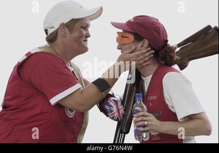 Anita North (Silbermedaillengewinnerin) von Left England gratuliert der kanadischen Cynthia Meyer (rechts) (Gewinnerin der Goldmedaillengewinnerin) nach dem Womens Trap Singles Finale der Commonwealth Games 2002 im National Shooting Center, Bisley. Stockfoto