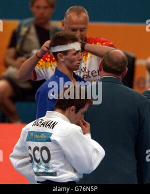 Der englische Craig Fallon hat seinen Kopf nach einem Zusammenstoß mit dem schottischen John Buchanan im 60 kg schweren Männer-Judo während der XVII Commonwealth Games in Manchester verbunden. Stockfoto