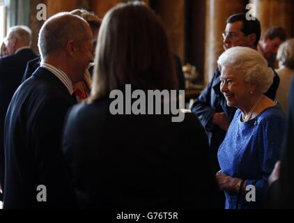 Queen Elizabeth II (rechts) begrüßt die Gäste bei einem Empfang im Buckingham Palace für die Gewinner der Queen's Awards for Enterprise 2014. Stockfoto