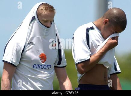 Damien Duff schützt sich vor der Sonne, als Steven Reid während eines Trainings der Republik Irland in Saipan, Commonwealth of the Northern Marianas, Schweiß von seinem Gesicht wischt, um das Eröffnungsspiel der Weltmeisterschaft gegen Kamerun am 1. Juni vorzubereiten. Stockfoto