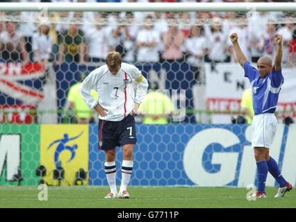 Englands Kapitän David Beckham ist niedergeschlagen, als der Brasilianer Roberto Carlos nach seinem Sieg über England 2-1 im WM-Viertelfinale im ecopa Stadium, Shizuoka, Japan, feiert. Stockfoto