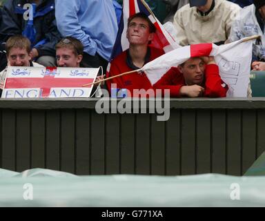 KEINE KOMMERZIELLE NUTZUNG. Tim Henman Tennis-Fans warten auf den Regen über Center Court passieren heute. Die Abdeckungen wurden entfernt und mehrmals zwischen Regenschauern wieder eingesetzt, wo Henman im Viertelfinale den Brasilianer Andre Sa spielen soll. Stockfoto