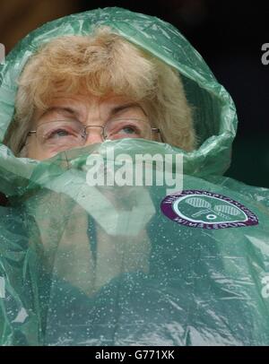 Wimbledon-Zuschauer versteckt sich vor Regen Stockfoto