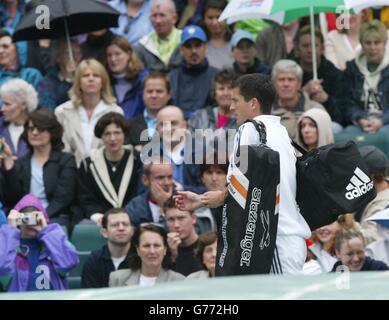 , KEINE KOMMERZIELLE NUTZUNG : Großbritanniens Tim Henman verlässt Center Court in Wimbledon nach Regen gezwungen ihn aus dem Gericht nach nur fünf Minuten. Er soll im Halbfinale den Top-Samen Lleyton Hewitt aus Australien spielen. Stockfoto